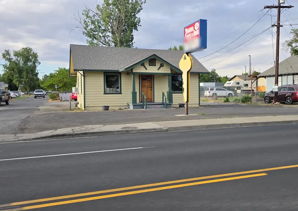 The yellow Yakima Lock & Safe bungalow with green trim and the giant yellow key on its pole sign on Nob Hill Blvd